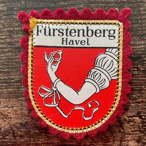 May include: A white ceramic mug with a wraparound design featuring a vibrant, colorful illustration of various mushrooms. The mug has a black handle and a glossy finish. The text "Shroom Queens" is printed on the mug.