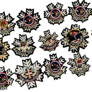 以下が含まれることがあります： さまざまなスキーリゾート名とロゴが刺繍されたパッチのコレクション。各パッチは、スキーヤー、シールド、またはエンブレムを備えた円形のデザインで、黒と白の雪片のようなボーダーで囲まれています。パッチはさまざまな色です。