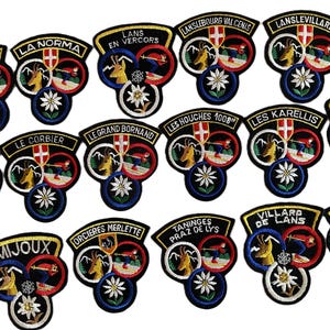 May include: A collection of embroidered patches featuring various French ski resort names. Each patch displays a mountain goat, a skier, a shield with a cross, and an edelweiss flower, all outlined in black with colorful thread accents.