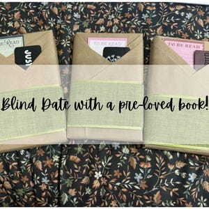 May include: Three wrapped books with the text "Blind Date with a pre-loved book!". Each book is wrapped in brown paper, with a green ribbon and a card that says "To Be Read".