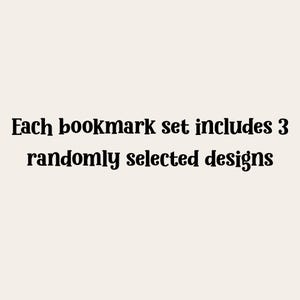 Puede incluir: Texto sobre un fondo crema: "Cada juego de marcap&aacute;ginas incluye 3 dise&ntilde;os seleccionados aleatoriamente."