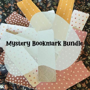 Puede incluir: Una colecci&oacute;n de marcadores variados con varios patrones y colores. Los marcadores presentan dise&ntilde;os como corazones, lunares y patrones florales. El texto "Mystery Bookmark Bundle" se muestra en negro.