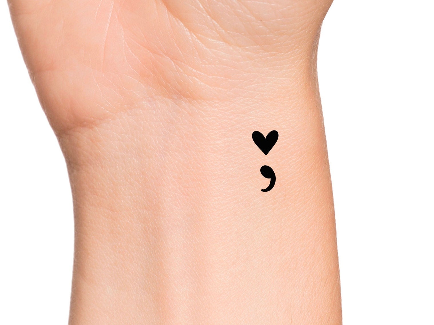 Minimalist semicolon tattoo on the ankle.