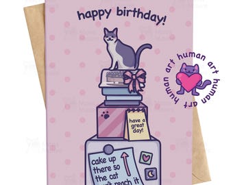 May include: A birthday greeting card with a cartoon cat sitting atop a stack of books and a cake. The card has the words "happy birthday!" and "cake up there so the cat can't reach it." The card is light pink with a brown envelope.