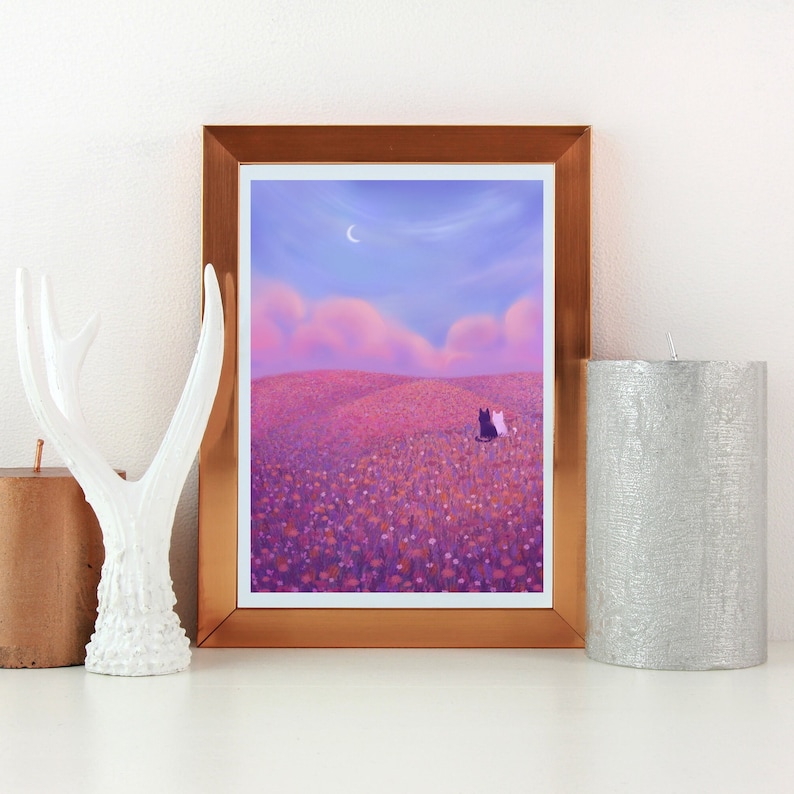 May include: A framed illustration of two cats sitting in a field of purple flowers under a crescent moon. The sky is a gradient of pink and purple.