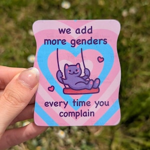 Könnte beinhalten: Ein rechteckiger Aufkleber mit abgerundeten Ecken, der eine violette Katze auf einer Schaukel in einem rosa-blauen Herzdesign zeigt. Der Text we add more genders every time you complain steht in violetten Buchstaben auf pastellfarbenem Grund.