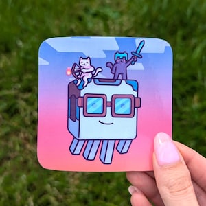 May include: Square sticker with a cartoon illustration of a light blue box character wearing glasses, with a smiling face. Two cat characters are on top, one with a bow and arrow, the other with a sword. The background is a gradient of pink, blue, and purple.