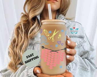 Könnte beinhalten: Ein brauner und beigefarbener Becher mit einem rosa und braunen Strickmuster, Schere, Garn und Herzen. Der Becher hat einen Bambusdeckel und einen Strohhalm. Der Text "KLO Tumblers" ist auf dem Becher sichtbar.