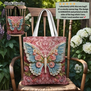 K&ouml;nnte beinhalten: Eine Tragetasche aus Canvas mit einem gro&szlig;en Schmetterlingsdesign. Der Schmetterling hat hellblaue und rosa Fl&uuml;gel mit floralen Akzenten. Die Tasche hat wei&szlig;e Griffe und schwarze Griffe auf dem inset Bild. Der Hintergrund ist ein rosa Blumenmuster.