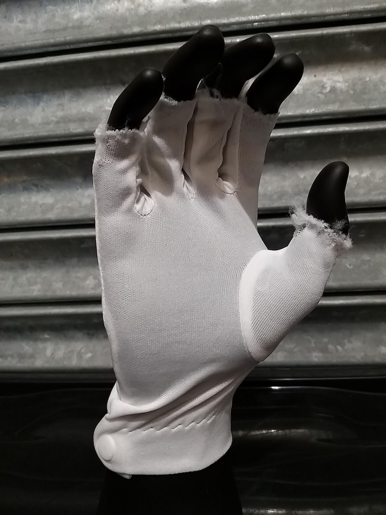 May include: White cotton gloves with a button closure on the wrist. The gloves are made of a thin, breathable fabric and are designed to protect hands from dirt and grime.