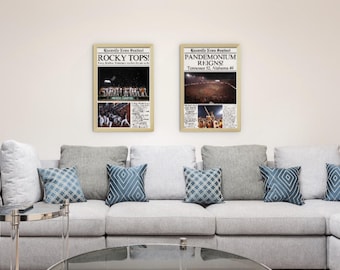 May include: Two framed newspaper clippings with headlines "ROCKY TOPS!" and "PANDEMONIUM REIGNS!"  The clippings are on a white wall above a gray couch with blue patterned throw pillows.