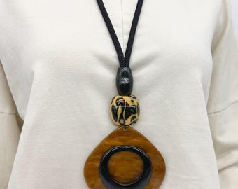 Bold and chunky gold bronze resin pendant with black cord