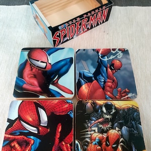 May include: Set of four square coasters featuring different images of Spider-Man in various poses. The coasters are made of wood and have a glossy finish. The box is made of wood and has a printed image of Spider-Man with the text "Peter Parker Spider-Man".