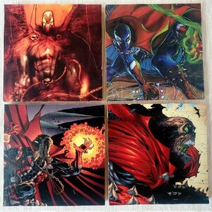 May include: Four trading cards featuring the comic book character Spawn. The cards feature different illustrations of Spawn in various poses and settings. The cards are in a red, black, and white color scheme.