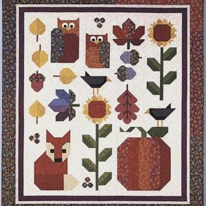 May include: A patchwork quilt featuring autumn-themed designs. The quilt showcases geometric shapes of owls, leaves, sunflowers, a fox, birds, and a pumpkin in shades of brown, orange, yellow, and green. The quilt has a floral border.