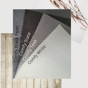 May include: Four fabric swatches in different shades of grey, from dark to light. The swatches are labelled "Comfy Black Pearl", "Comfy Slate", "Comfy Teak", and "Comfy White".