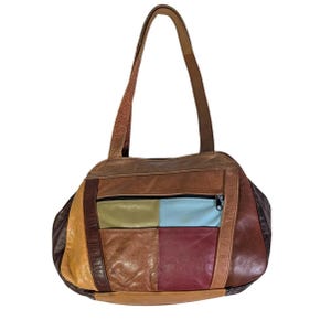 May include: A multi-colored leather shoulder bag featuring a patchwork design with panels in shades of brown, tan, olive green, light blue, and deep red. The bag includes a zippered front pocket, a main compartment, and two long shoulder straps.