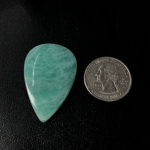 Pu&ograve; includere: Un cabochon di acquamarina di colore blu chiaro a forma di lacrima, che misura circa le dimensioni di una moneta da 25 centesimi di dollaro americano.