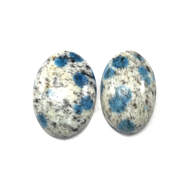 May include: Two oval-shaped blue and white speckled cabochons. The cabochons are approximately 1 inch in length and 3/4 inch in width.