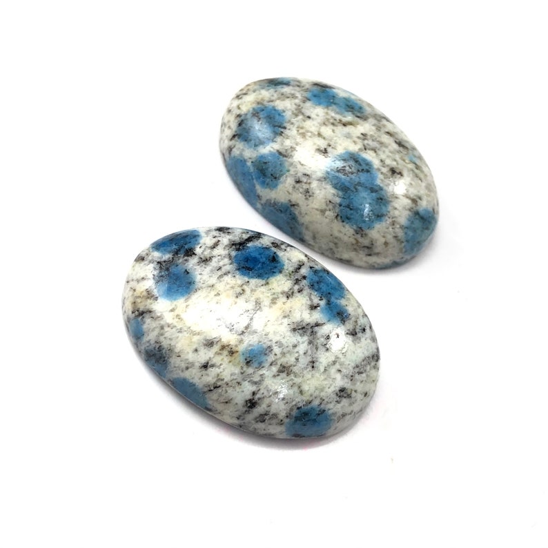 May include: Two oval-shaped blue and white speckled stones. The stones have a smooth, polished finish.