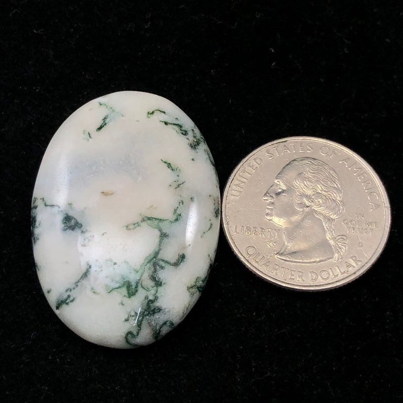 Pode incluir: Um caboch&atilde;o de &aacute;gata branco e verde com um padr&atilde;o de redemoinho. O caboch&atilde;o &eacute; aproximadamente do tamanho de uma moeda de 25 centavos de d&oacute;lar americano.
