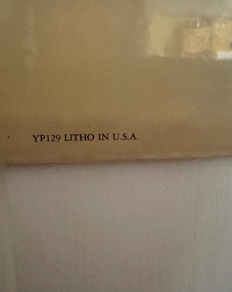 May include: A close-up of a beige-colored surface with the text "YP129 LITHO IN U.S.A." printed in black. The image has a soft, diffused lighting.