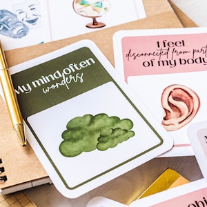 May include: A set of cards with illustrations and text. The cards feature phrases like "My mind often wonders" and "I feel disconnected from parts of my body".