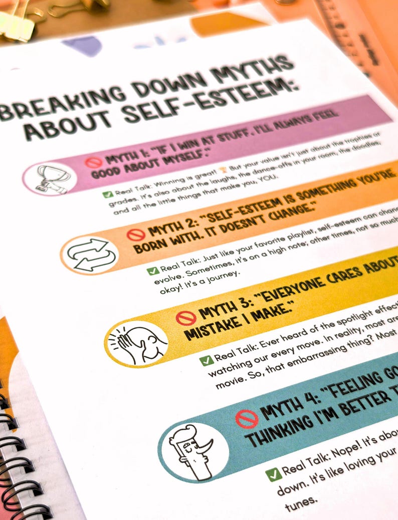 Puede incluir: P&aacute;gina de cuaderno con el t&iacute;tulo "BREAKING DOWN MYTHS ABOUT SELF-ESTEEM". Se enumeran cuatro mitos con secciones de "Real Talk". Los mitos se destacan con barras de colores e ilustraciones.