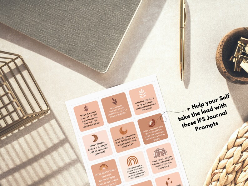 May include: A set of IFS Journal Prompts with a neutral color palette. The prompts are on square cards with icons and questions. A gold pen, a notebook, and a small gold wire basket are also in the image. The text reads: "Help your Self take the lead with these IFS Journal Prompts."