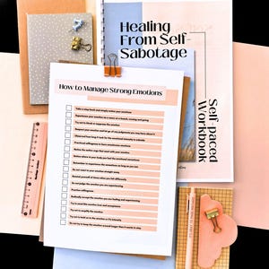 a variety of items, including a clipboard with a list of steps for managing strong emotions, a self-paced workbook, a ruler, a pen, and a small cloud-shaped object.