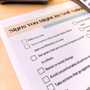 a close-up view of a document titled "Signs You Might Be Self-Sufficient" with a list of personal development goals and behaviors.