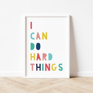 May include: A white framed print with the text "I CAN DO HARD THINGS" in colorful letters. The letters are in different colors, including red, yellow, blue, green, and pink.