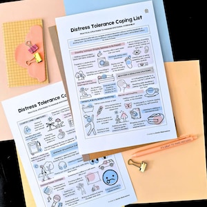 May include: A flat lay featuring two printed sheets titled "Distress Tolerance Coping List" with coping strategies, alongside a peach pen, paper clips, and a notepad. The pen reads "IT'S OKAY TO MAKE MISTAKES". The background is a mix of peach, blue, and yellow.