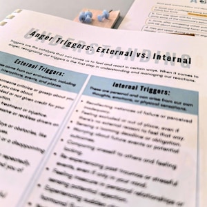 a close-up view of a printed document or worksheet with text and bullet points, with a small wooden block or object placed on top of it.