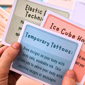 a person's hands holding a set of temporary tattoos instructions.