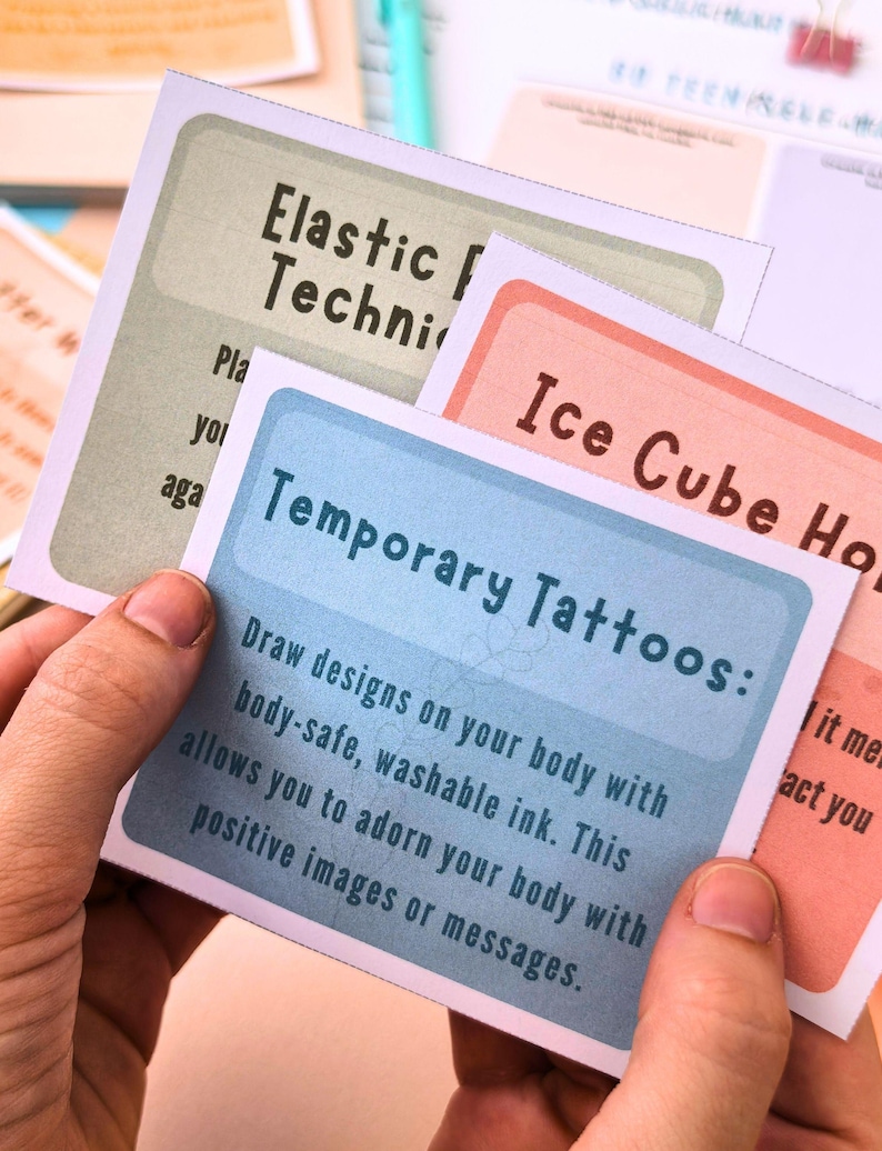 a person's hands holding a set of temporary tattoos instructions.