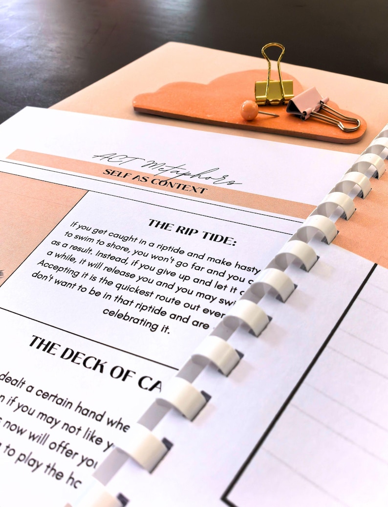 a spiral-bound notebook with a page titled "The Rip Tide" and a binder clip on top of it. The notebook appears to be open, and the page contains text that is partially visible.