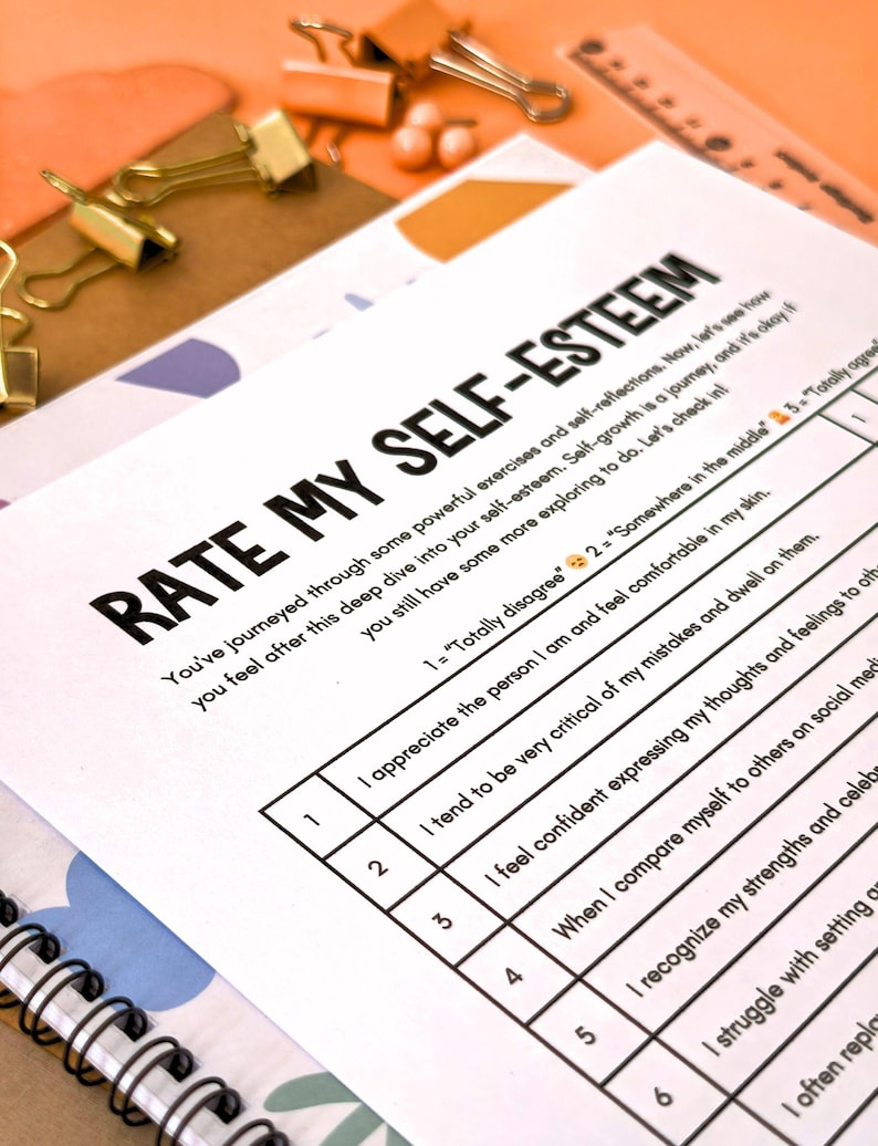 Puede incluir: Primer plano de una hoja de trabajo de evaluaci&oacute;n de la autoestima titulada "RATE MY SELF-ESTEEM". La hoja de trabajo est&aacute; en papel blanco con texto negro y una cuadr&iacute;cula para calificar las afirmaciones. Clips dorados y una regla en el fondo.