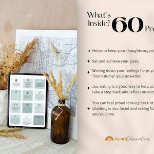 May include: A digital tablet displaying a set of 60 journal prompts with a light blue background and black icons. The text "What's Inside? 60 Prompts" is displayed in black text on a light beige background. The tablet is on a white surface with dried flowers and a brown glass bottle.