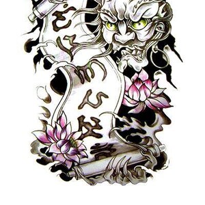 Puede incluir: Tatuaje temporal con una ilustración detallada de un demonio japonés con ojos verdes, sosteniendo un pergamino. El diseño incluye flores de loto y caracteres japoneses, con el texto "WannaBeInk.com TEMPORARY TATTOOS".