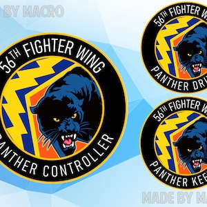 May include: Three black and gold round stickers with a black panther graphic and the text "56th Fighter Wing" and "Panther" followed by "Driver", "Controller", or "Keeper".