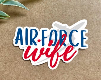 May include: A white sticker with a blue and red design that says "AIR FORCE wife" with a silhouette of an airplane in the background.