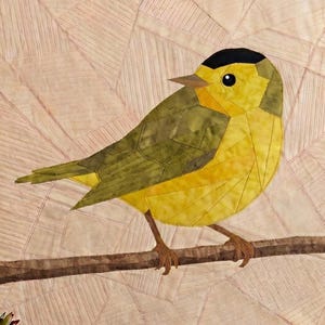 May include: A fabric quilt block featuring a pieced bird with a black cap, yellow breast, and olive green wings perched on a brown branch. The background consists of light beige fabric with intricate geometric stitching patterns throughout.