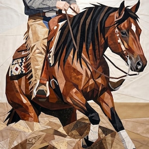 May include: A fabric quilt wall hanging depicting a brown horse with a black mane and tail, ridden by a person wearing a patterned shirt and tan chaps. The horse wears a saddle with a geometric blanket and white leg wraps, set against a light background.