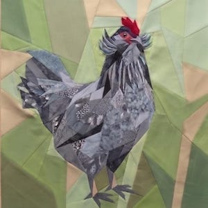Könnte beinhalten: Ein Stoff-Quiltblock mit einem aus Stoffstücken zusammengesetzten Huhn in Grau-, Schwarz- und Weißtönen mit verschiedenen Mustern. Das Huhn hat einen leuchtend roten Kamm und ist vor einem geometrischen Hintergrund aus hellgrünen Stoffdreiecken.