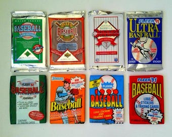 May include: Eight vintage baseball card wax packs from the 1990s, including brands like Fleer, Donruss, and Upper Deck. The packs feature colorful graphic designs, baseball imagery, and text such as Major League Baseball, 1990 Edition, 1991, 1992, and 1993.