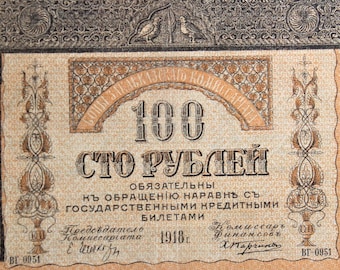 May include: A vintage Russian banknote with a value of 100 rubles. The note features an ornate design with a large number "100" and the text "СТО РУБЛЕЙ" in Cyrillic script. The note is dated 1918 and includes the signature of the Finance Commissar, "X. Karpunov".