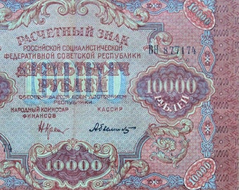 May include: A vintage Russian banknote with a value of 10,000 roubles. The note features a red and blue design with ornate details and the text "Расчетный знак" (payment token) and "Российской Социалистической Федеративной Советской Республики" (Russian Socialist Federative Soviet Republic).