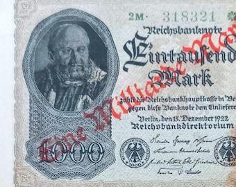 May include: A 1922 vintage 1000 Mark Reichsbanknote, with a portrait in an oval frame. The banknote displays detailed German text and the Reichsbankdirektorium seal. The number 1000 is clearly visible on the note.
