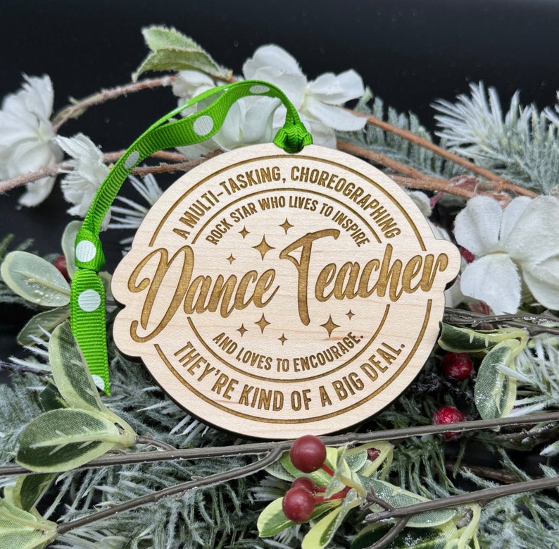 Puede incluir: Un adorno de madera con fondo marr&oacute;n y texto blanco. El texto dice "A multi-tasking, choreographing rock star who lives to inspire Dance Teacher and loves to encourage. They're kind of a big deal."